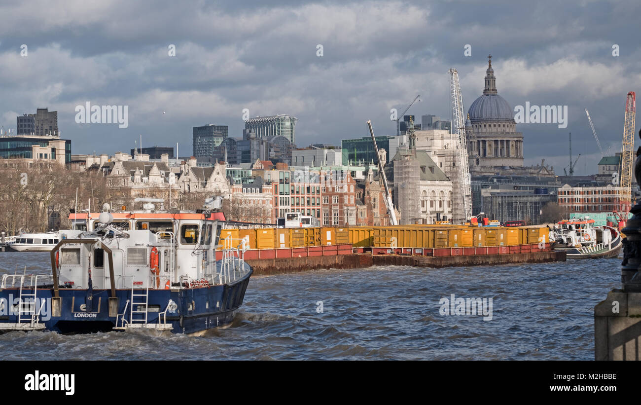 Barge und anderen gewerblichen Verkehr Verfahren nach Osten entlang der Themse in der Nähe von Waterloo Bridge mit St. Paul's Kathedrale im Hintergrund Stockfoto