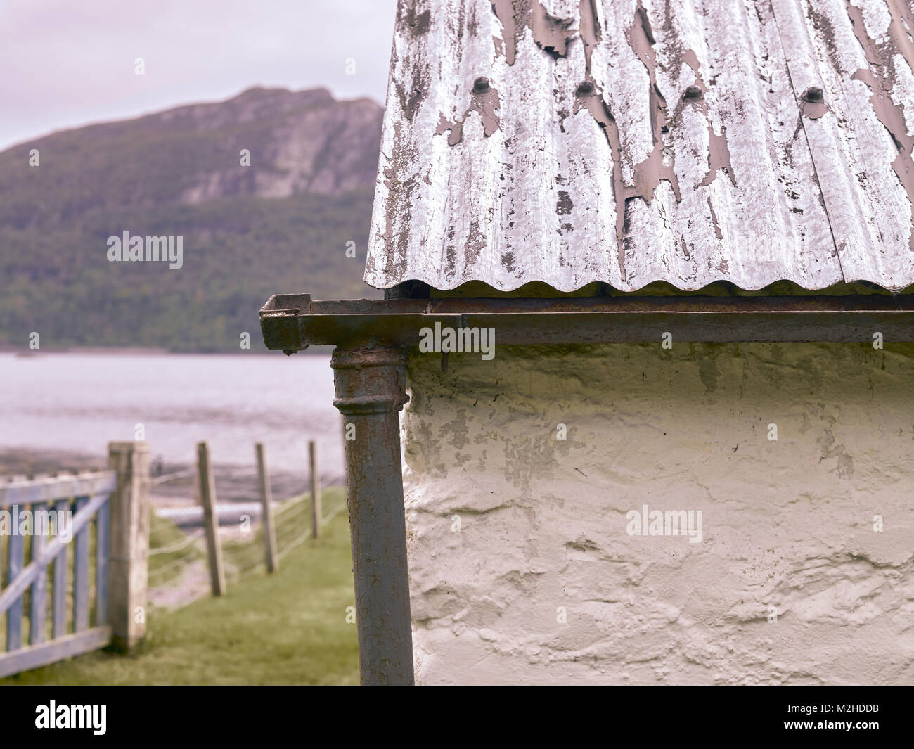 Detail der Wellblechdach, Gusseisen Regenrinne und unten am Ufer des Loch Carron an Ardaneaskan Clachan Cottage. Stockfoto