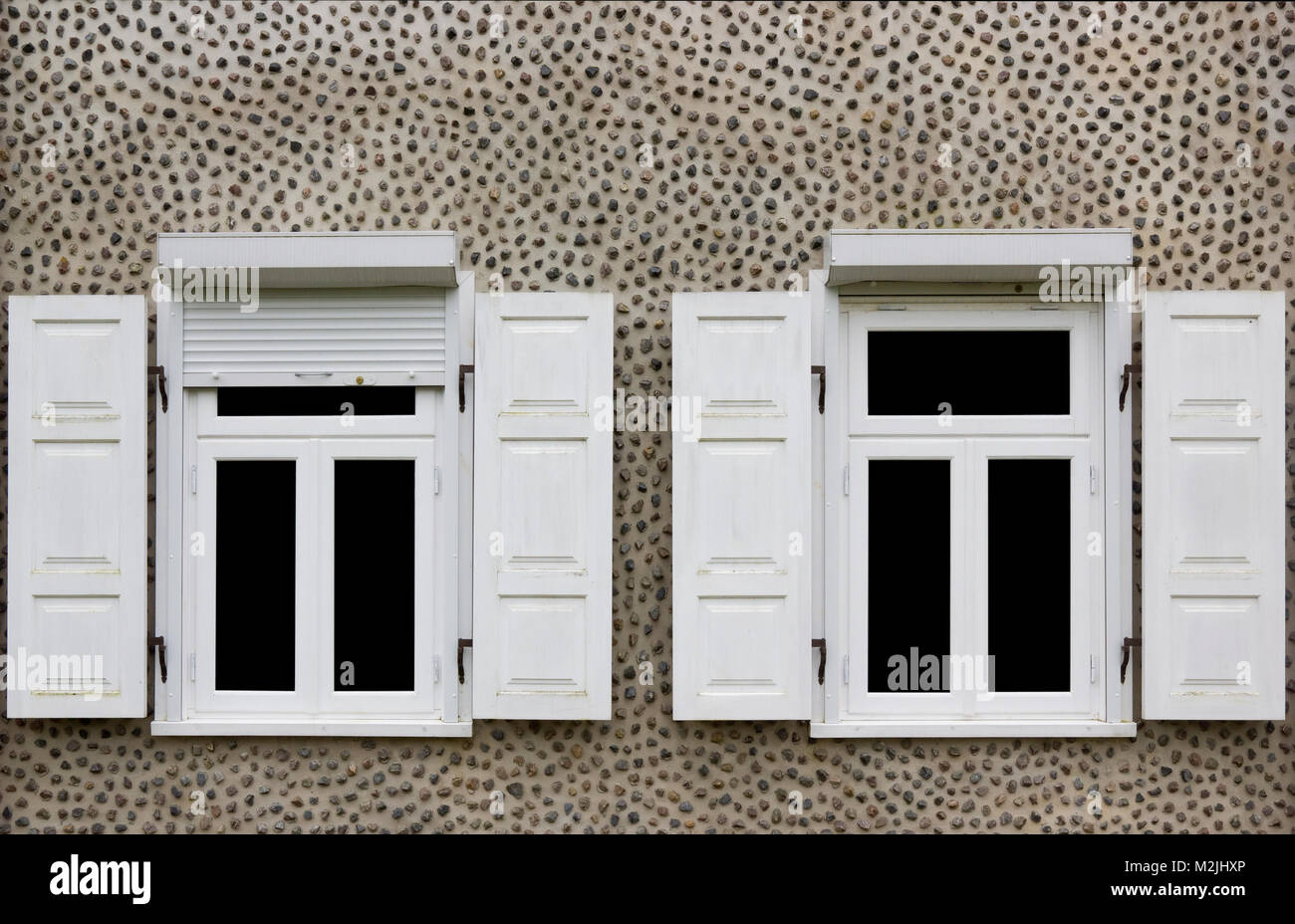 Zwei weiße eröffnet neue Fenster mit Jalousien. Home Wand mit kleinen Granit Steinen verziert. Glas isoliert auf Schwarz Stockfoto