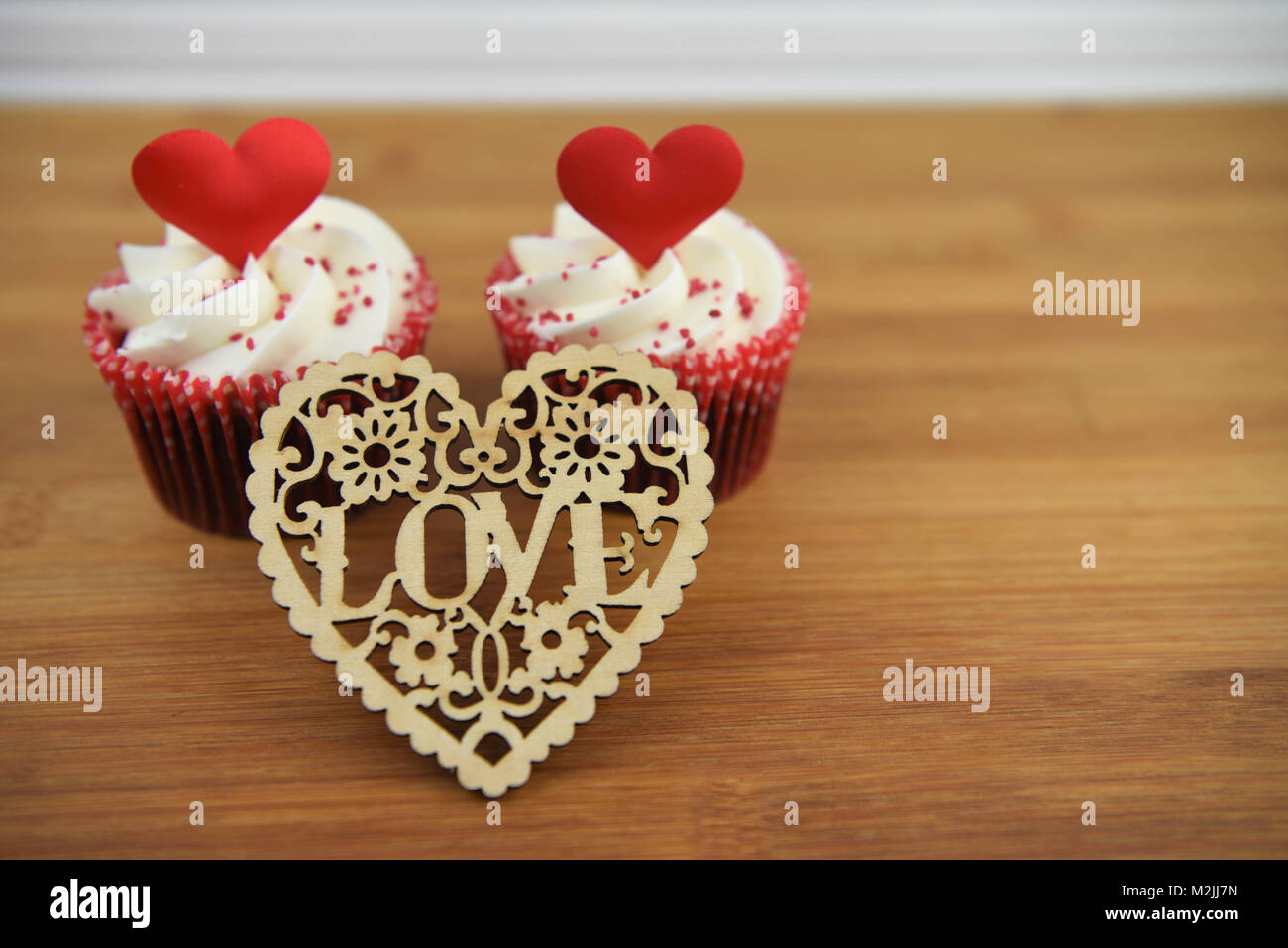 Gesund essen von Cupcakes mit weißen Swirl buttercream Topping und Rote Liebe Herz Form Dekorationen für Valentinstag oder Hochzeitstag Stockfoto