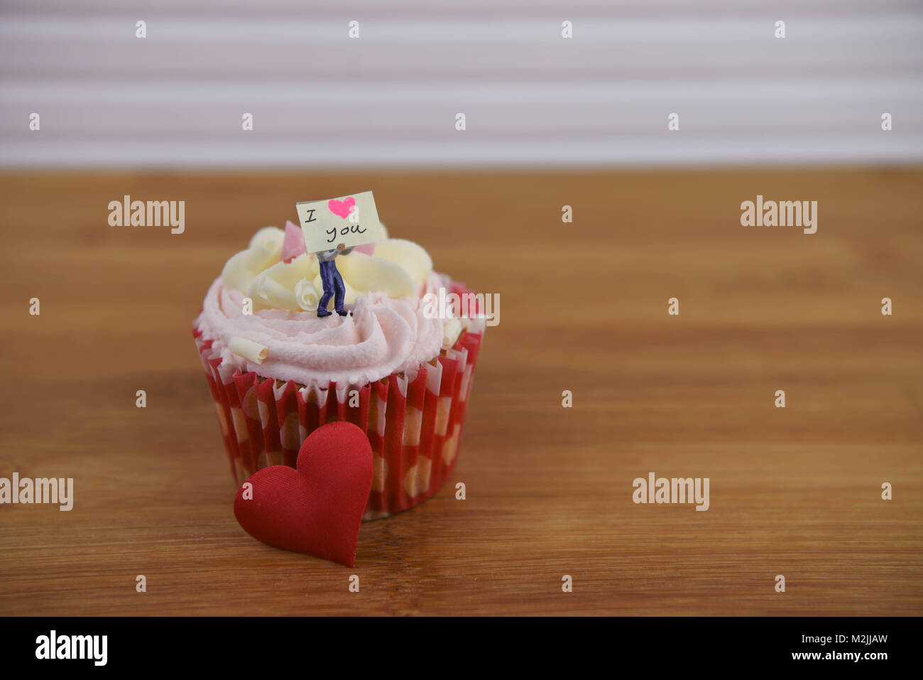 Romantischer Valentinstag Cupcake mit einer Miniatur person Figur hält ein Schild und Rote Liebe Herz Formen dekoriert Stockfoto