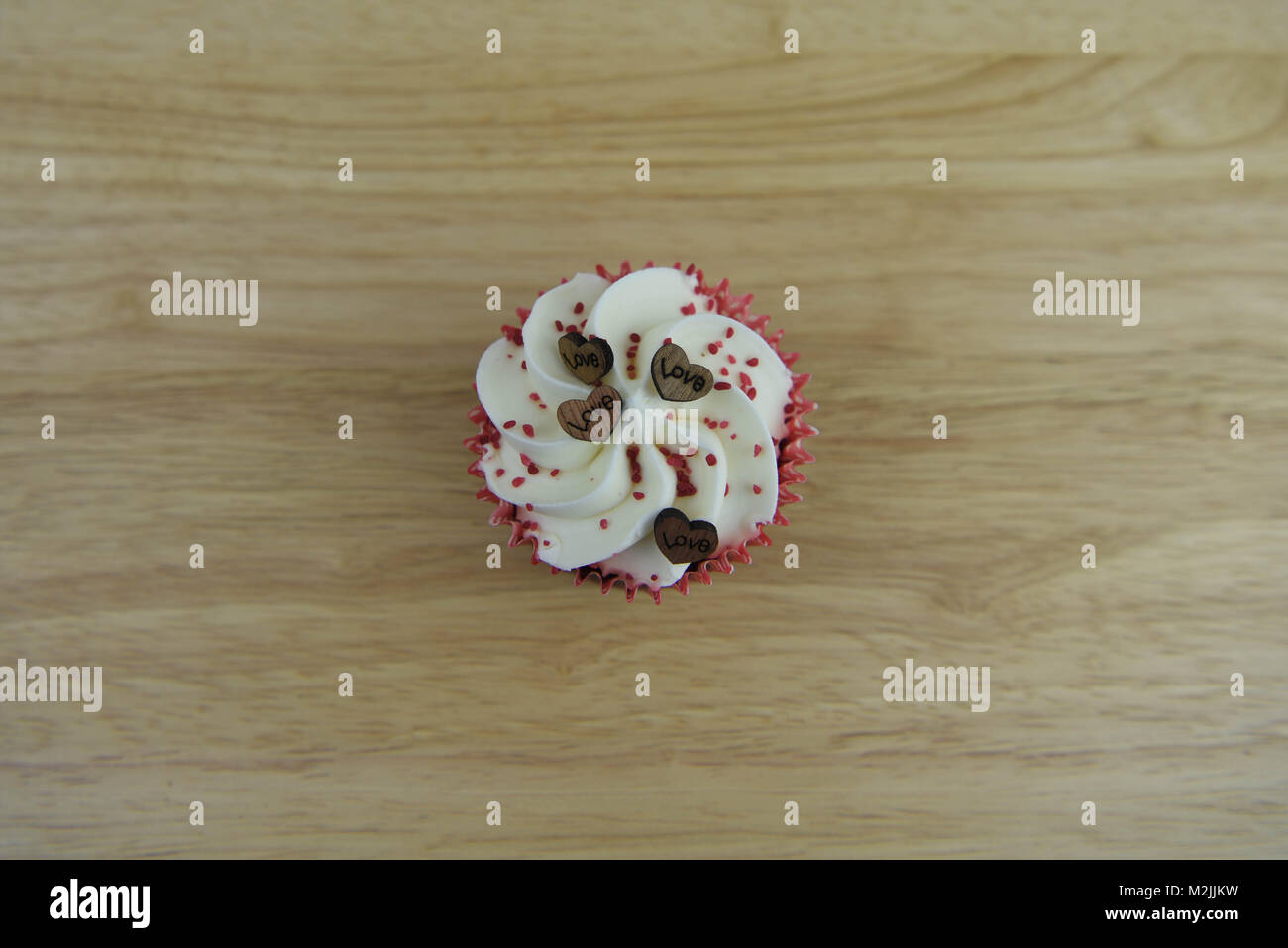 Köstliche Valentines Tag handgefertigte Cupcake mit buttercream und roten besprüht und Holz- Liebe Herz formen und das Wort Liebe Stockfoto