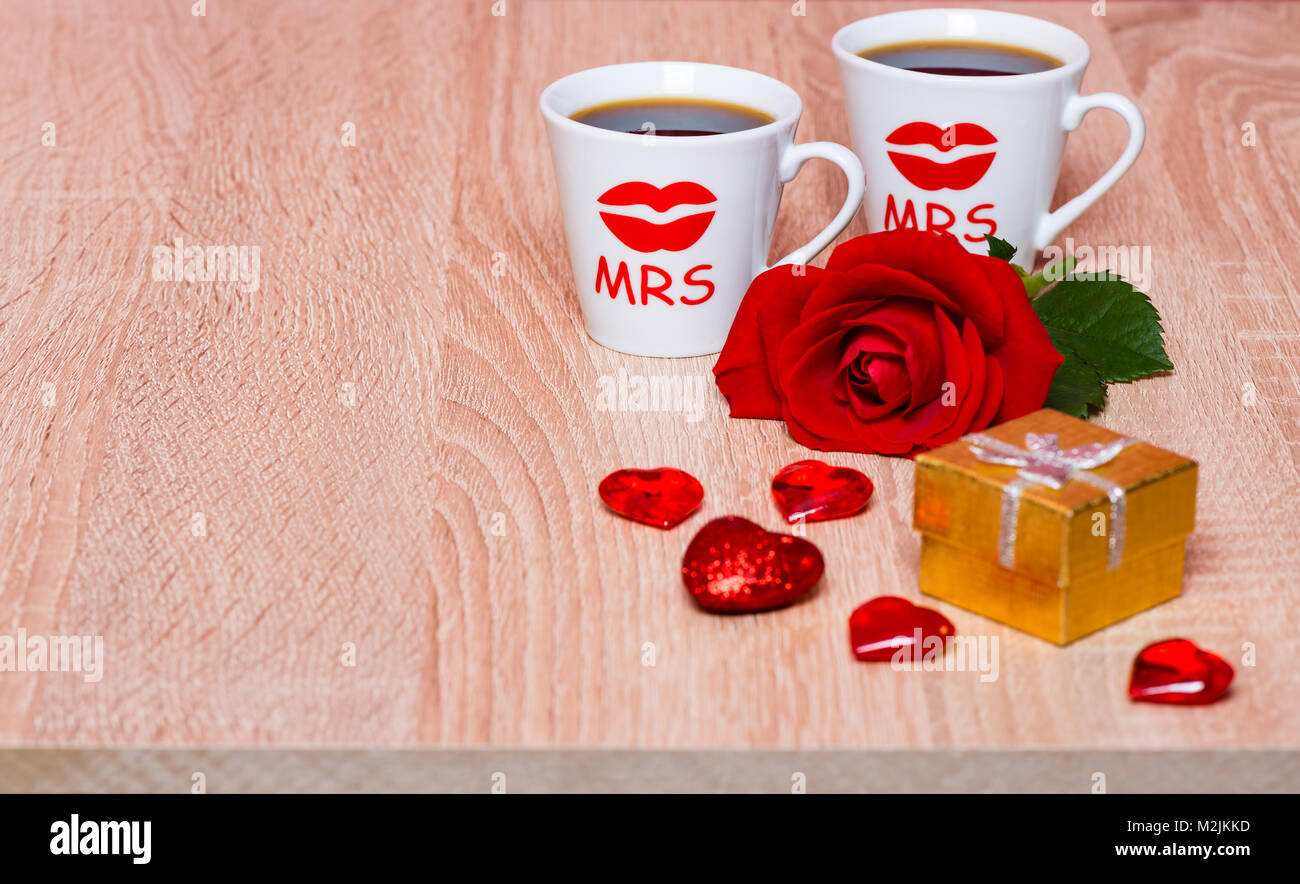 Lesbische ehe Konzept. Zwei Tassen Kaffee, Rose Blume und Geschenk Stockfoto
