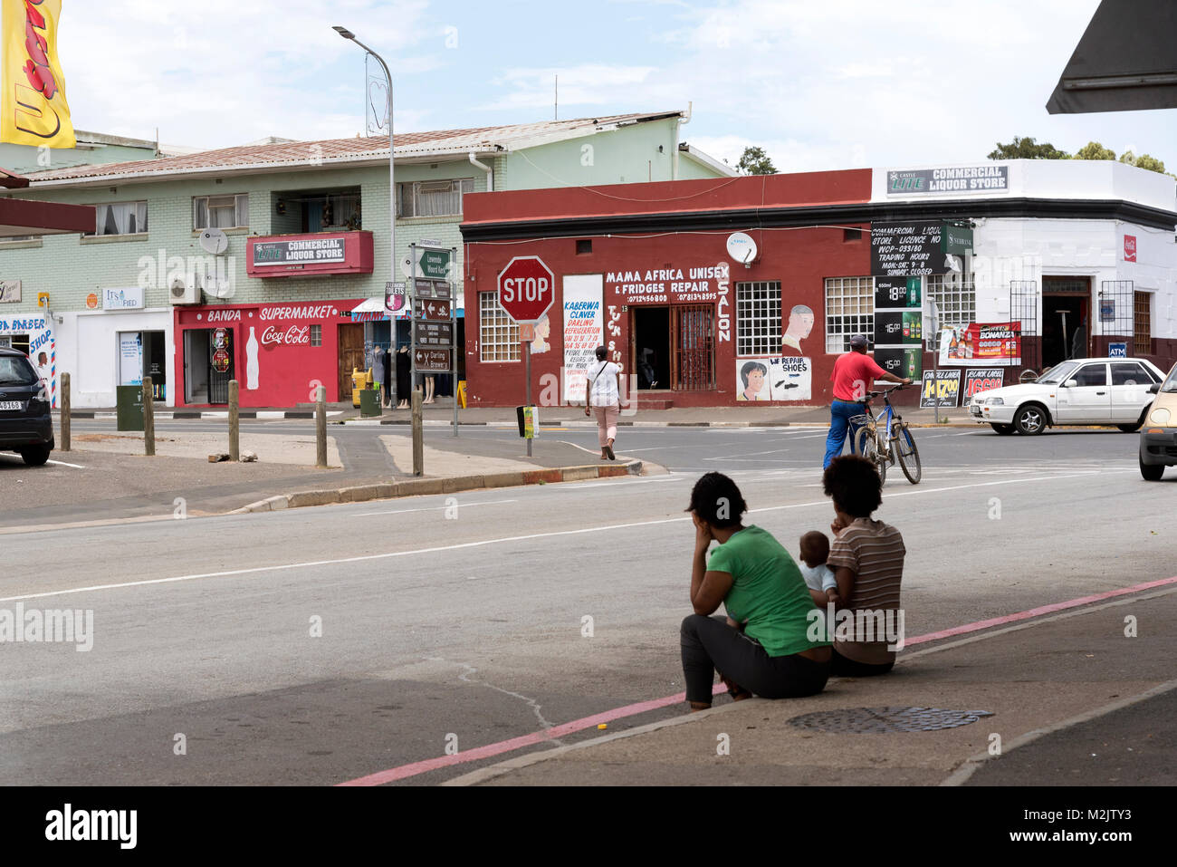 Stadtzentrum von Darling in der Western Cape Region Südafrikas. Lokale Frauen sitzen mit einem Kind, das am Straßenrand Stockfoto