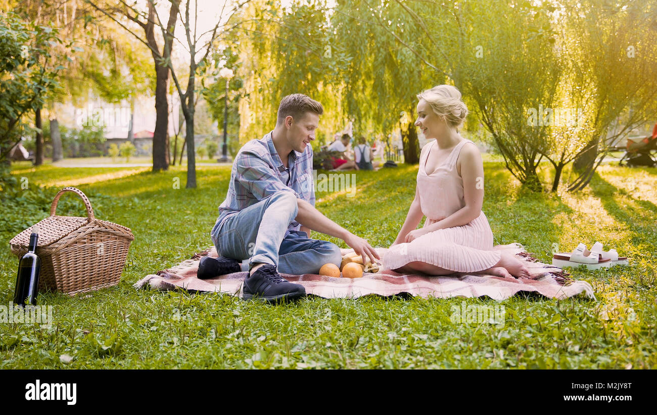 Junge liebende Paar lachen und Spaß haben, Ausgabe von Datum und Zeit in den öffentlichen Park Stockfoto