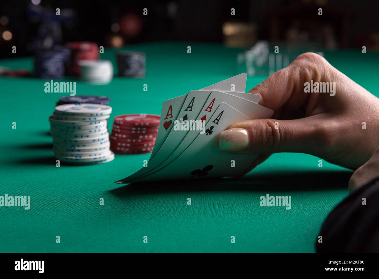 Poker Tisch während eines Spiels. Vier Asse Karten in der Hand halten. Chips und Karten auf den Tisch. Stockfoto