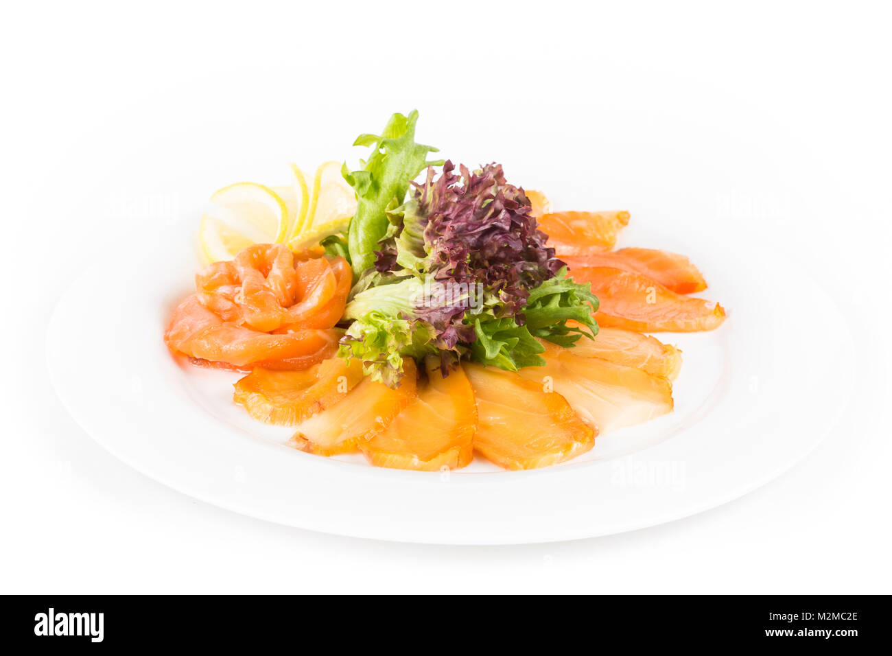 Sortierte Fische auf einem Teller mit Salat und Zitrone auf einem weißen Hintergrund. Eine Platte mit Fisch sortierten isoliert Stockfoto