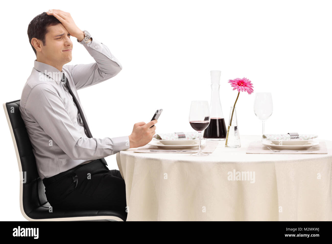 Enttäuscht Mann an einem Tisch im Restaurant sitzt nach dem Lesen einer Nachricht auf sein Handy auf weißem Hintergrund Stockfoto