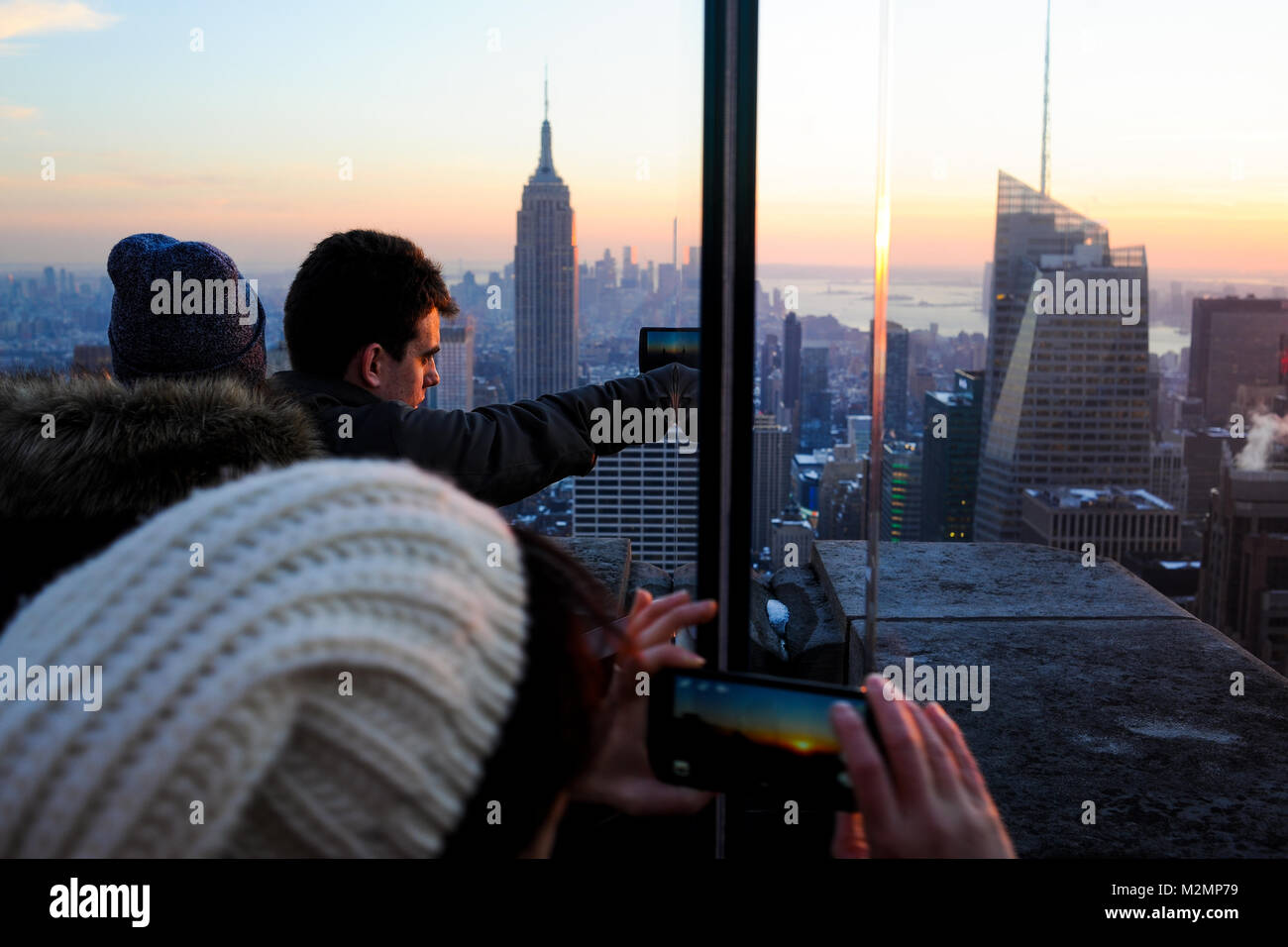 Touristen machen Fotos von den Sonnenuntergang vom Rockefeller Center in New York City. s Stockfoto