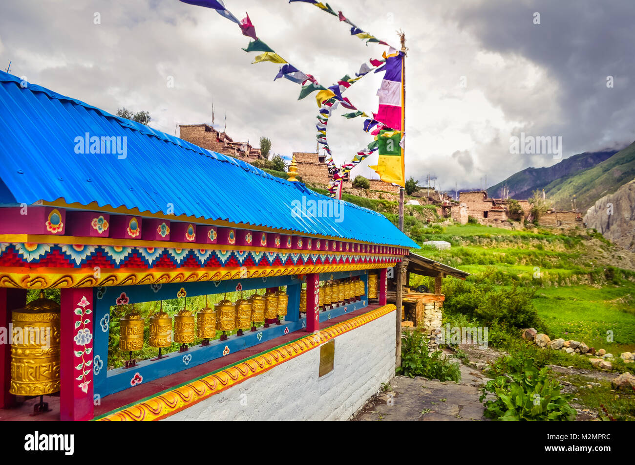 Lokale Exploration, Gebetsmühlen und Gebetsfahnen in einem kleinen Dorf namens Manang, während der Annapurna Circuit Trek in der Monsunzeit erfasst Stockfoto