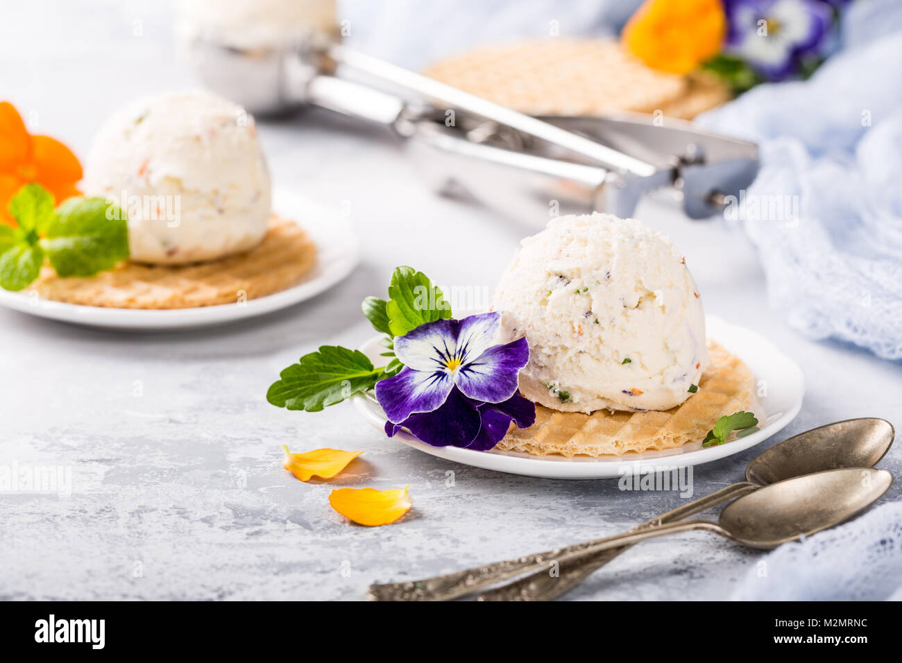Vanilleeis mit essbaren Blüten Stockfoto