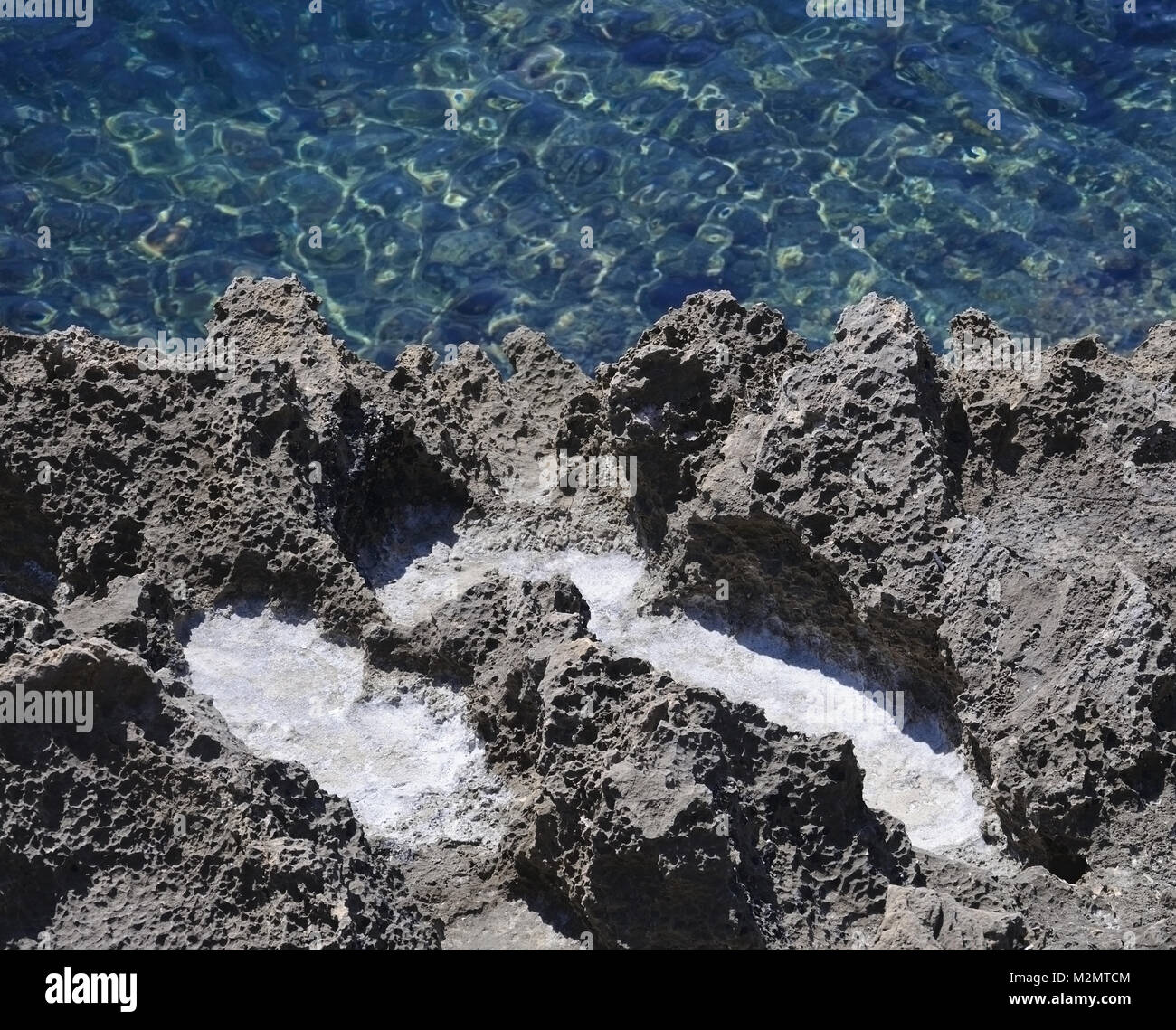 Salz Niederschlag in erodiert Schwarz oxidiert Kalkstein Hohlräume in der Nähe von salzhaltigen Umgebung auf Mallorca Im Mittelmeer Ozean. Stockfoto