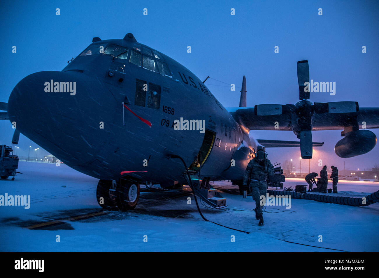 Flieger arbeiten an der Bremse Systeme einer C-130H Hercules während eines Schneesturms, 07.02.2018, an der 179th Airlift Wing, Mansfield, Ohio. Die 179Th Airlift Wing Maintenance Group prüft regelmäßig, alle Aspekte ihrer Flugzeuge mission Bereitschaft mit bereit Flieger und Flugzeuge bereit zu halten. (U.S. Air National Guard Foto von Tech. Sgt. Joe HarwoodReleased) Stockfoto