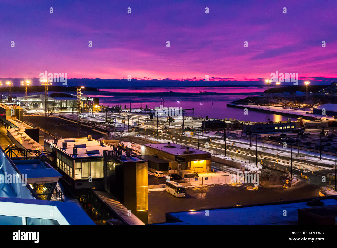 Lila Sonnenuntergang über dem Hafen von Helsinki, der Hauptstadt von Finnland, von der eine der Fähren Stockfoto