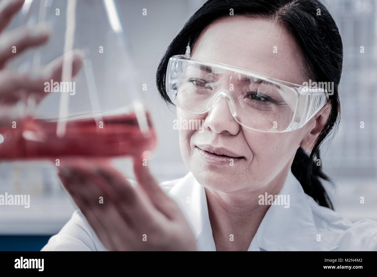 Fokussierte weiblichen professionellen Prüfung von chemischen Flüssigkeiten im Labor Stockfoto