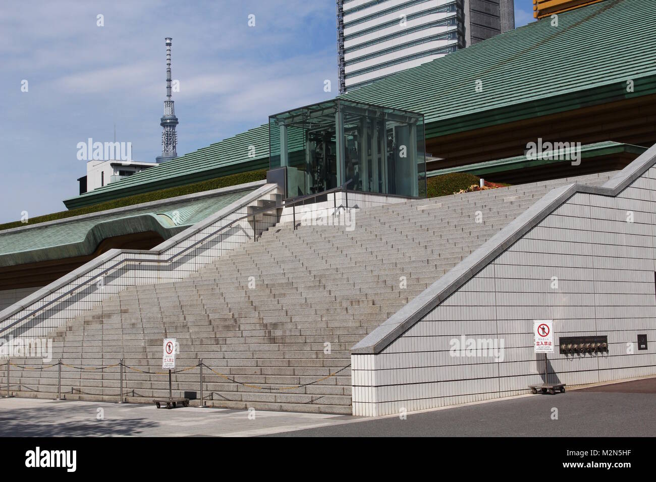 Der Ryogoku Kokugikan, eine Sportarena hauptsächlich für Sumo mit Tokyo Skytree im Hintergrund verwendet. Es wird als Veranstaltungsort der Olympischen Spiele 2020 eingesetzt werden. Stockfoto