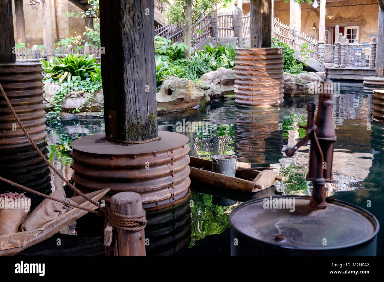 Gerippte Metallgehäuse an der Basis der hölzernen Pfählen im Wasser. Stockfoto