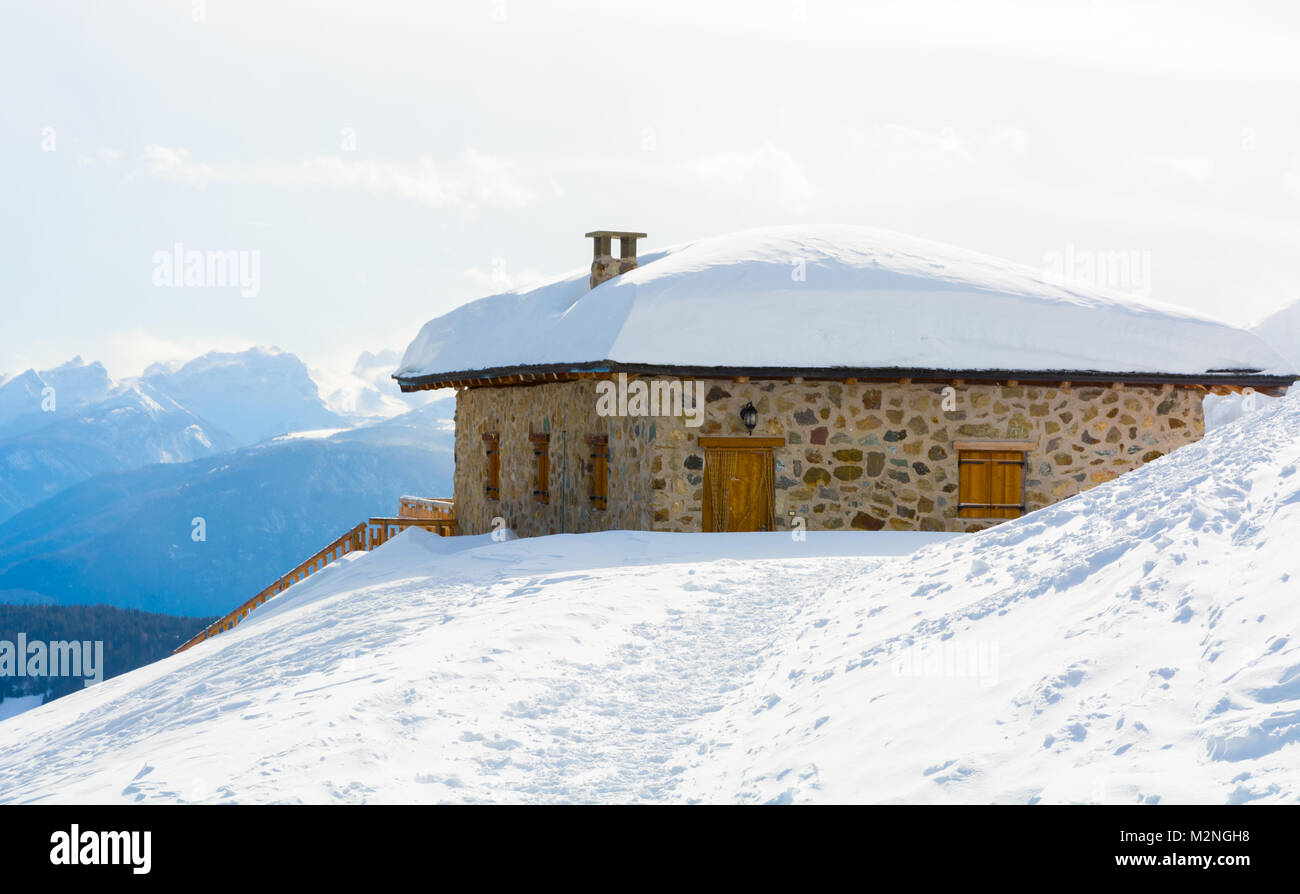 Panoramablick auf die idyllische Winterlandschaft mit Gipfeln und traditionelle Berghütte in den Dolomiten im Licht des Sonnenuntergangs Stockfoto