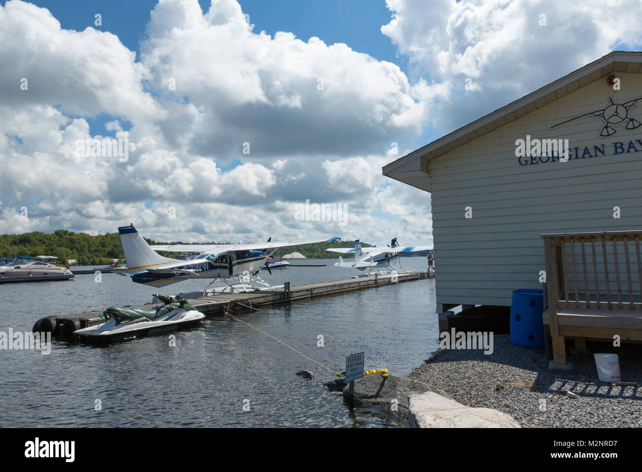 Angedockt air tour Wasserflugzeuge malerische Ferienhäuser Flüge, Georgian Bay Waterfront, Parry Sound Ontario Kanada, dramatische Tiefe in blauer Himmel und Wolken cumulus Stockfoto