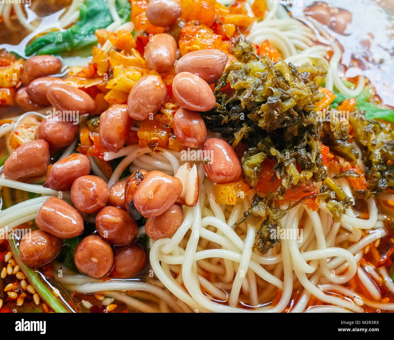 Würzige Nudelsuppe mit Gemüse, Kräutern, Erdnüssen und Koriander, beliebt in der Provinz Yunnan, geringe Tiefenschärfe, China. Stockfoto
