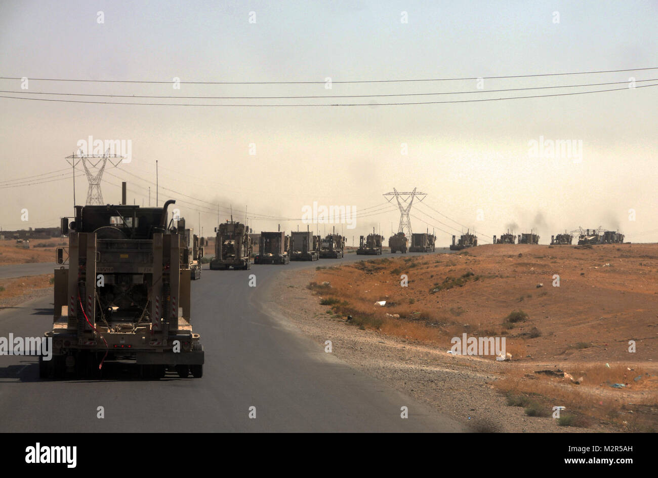 Schwere Ausrüstung transportiert, die die 129 Transport Unternehmen Konvoi nach unten eine Landstraße, Sept. 13, 2011 im Irak. Die 129 sind Soldaten aus der neuen Jahrhundert, Kan., zugeordnet zu unterstützen ist der 230ste Sustainment Brigade Joint Task Force Hickory, Ausrüstung aus schließen Stützpunkte als Teil der Verantwortung entziehen der US-Streitkräfte vom 31. Dez. Frist zu schleppen. Konvoi durch US-Truppen im Irak (Inaktiv) Stockfoto