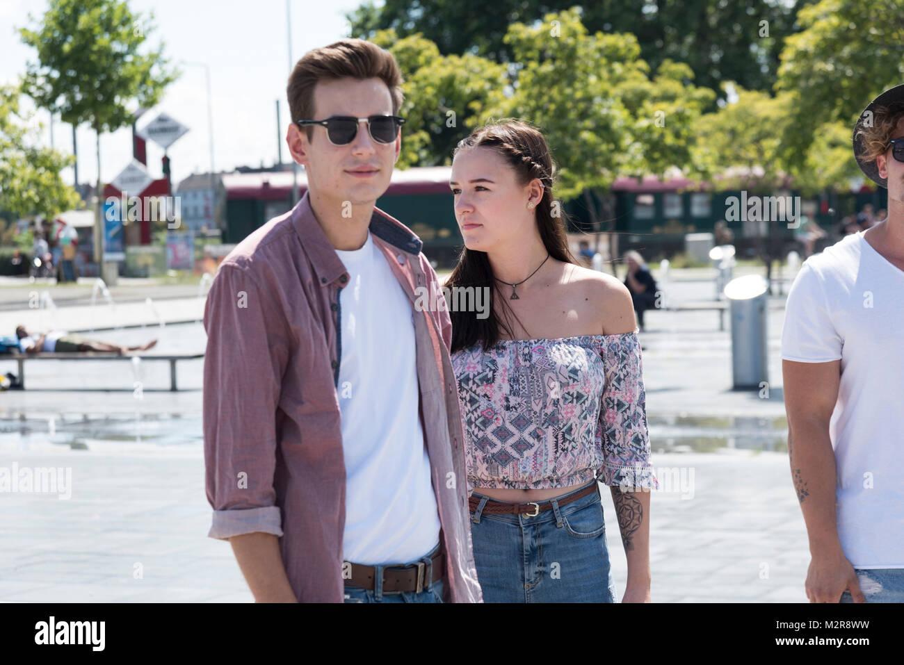 Zwei junge Männer und ein Mädchen in der Stadt Stockfoto