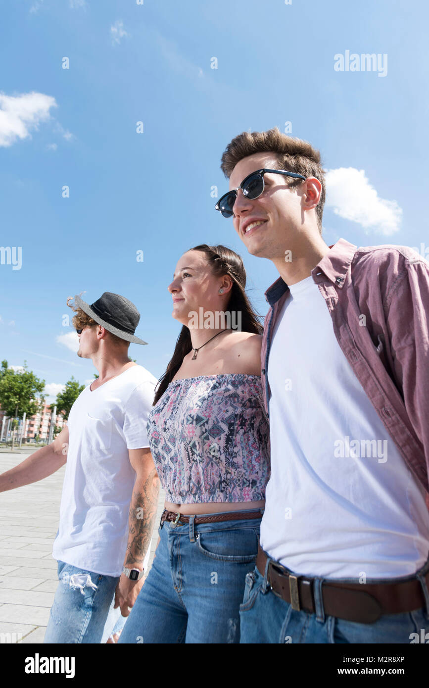Zwei junge Männer und ein Mädchen in der Stadt Stockfoto