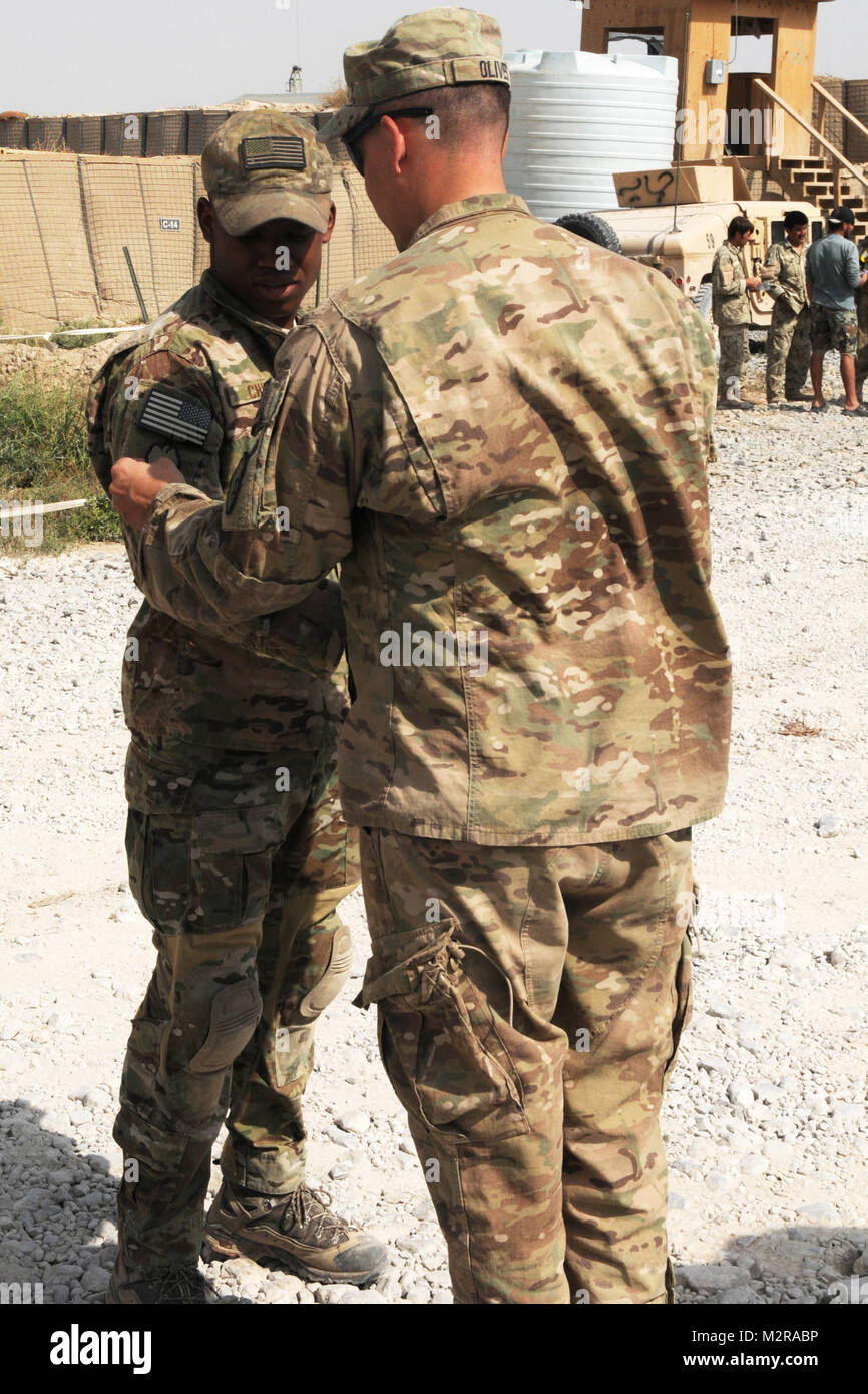 Kapitän John Oliver (rechts), Kommandant der Firma A, 3.Bataillon, 21 Infanterie Regiment, 1 Stryker Brigade Combat Team, 25 Infanterie Division, Orte des 25 ID-Patch auf der rechten Schulter der Air Force Staff Sgt. Brandon Chism, Okt. 23, bei der Bekämpfung der Vorposten Talukan. Chism, eine Beseitigung von Explosivstoffen Techniker mit dem 466Th Air Expeditionary Squadron, dient unter Oliver's Battalion. Der Verschleiß der 'Combat patch' ist eine Armee Tradition, und denen direkt im Kampf mit einer bestimmten Einheit ausgezeichnet. Obwohl die Luftwaffe hat diese Tradition nicht tragen, Oliver sagte, er wolle zu prese Stockfoto