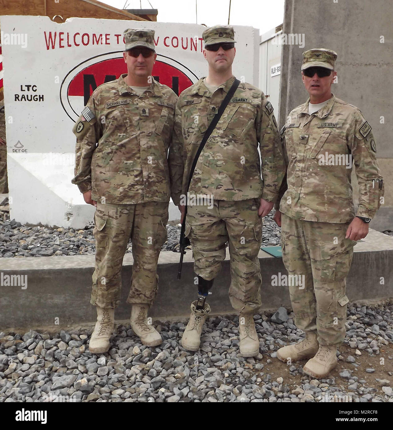 (Von links nach rechts) den Befehl Sgt. Maj. Joseph McFarlane, 5 Staffel, 1.Kavallerie Regiments, Staff Sgt. Brian Beem, und Oberst Todd R. Holz, Kommandant der 1. Stryker Brigade Combat Team, 25 Infanterie Division nehmen Sie sich einen Moment Zeit für eine sofort nach der Eintragung Zeremonie für Beem am Vorwärts Operating Base Frontenac, südlichen Afghanistan Nov. 9 Bild zu stellen. Beem ist ein amputee, die weiterhin mit dem 1/25 SBCT zu dienen. Er erlitt die Verletzung während einer Bereitstellung in den Irak im Jahr 2006. (U.S. Armee Foto: Sgt. Thomas Duval 1/25 SBCT Public Affairs) 111109-A-werden 343-007 von 1 Stryker Brigade Kamm Stockfoto