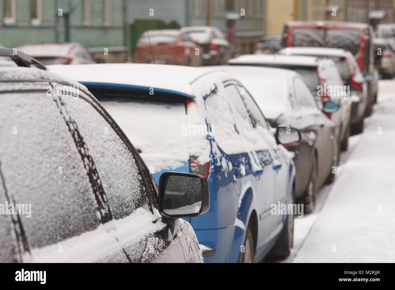Städtische Szene der Straße mit parkenden Autos von Schnee Winter Tag Stockfoto