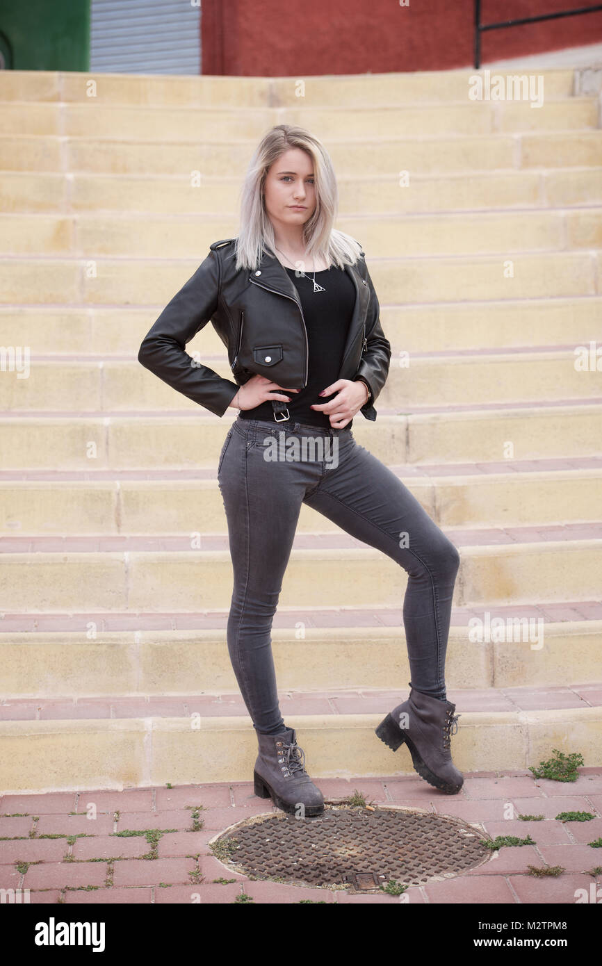 Schöne blonde Mädchen mit engen Jeans und ein schwarzes T-Shirt im Freien  Stockfotografie - Alamy