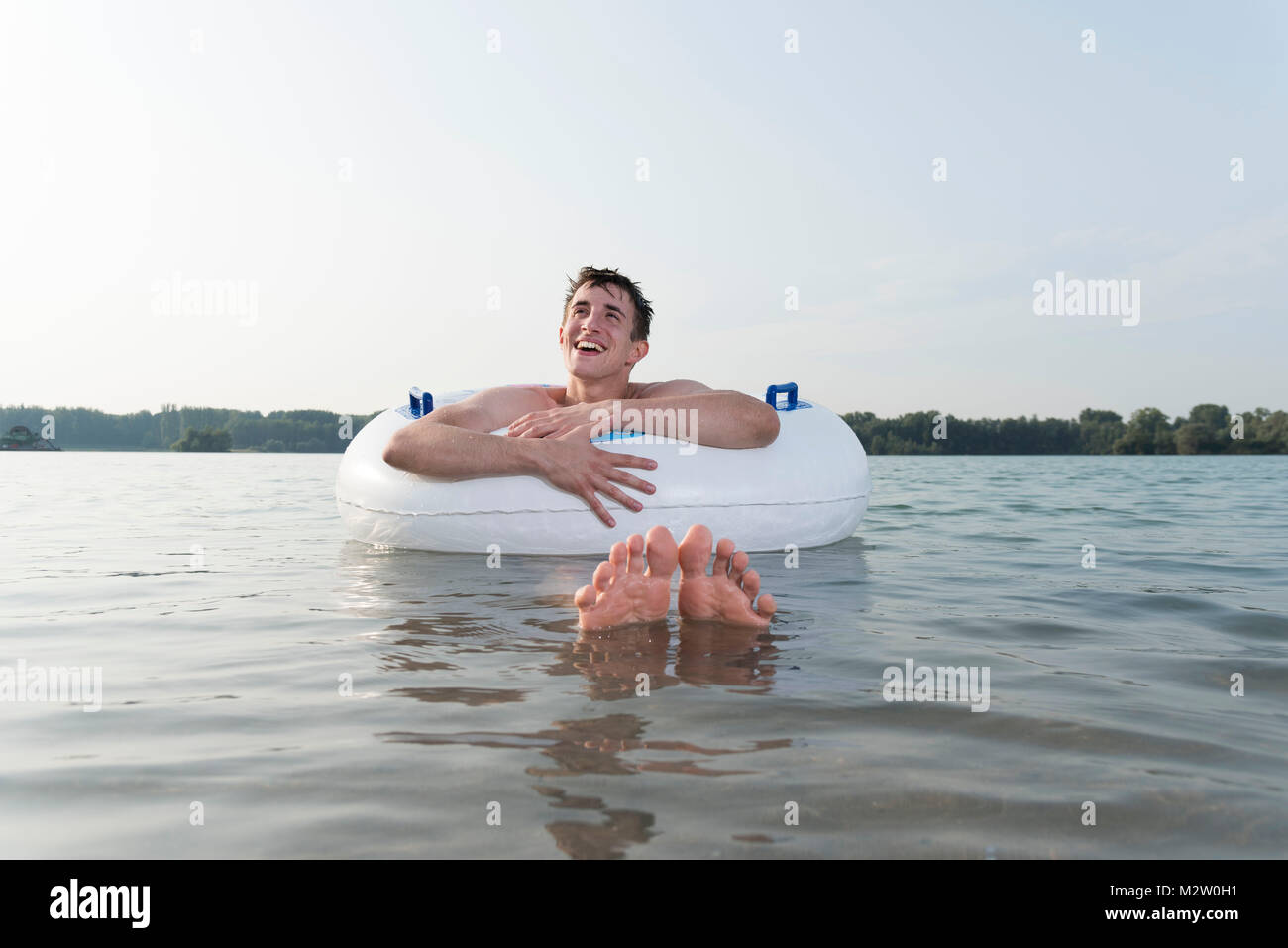 Junge Mann in der Nähe schwimmen Ring in der See, baggersee Liedolsheim, Dettenheim, Baden-Württemberg, Deutschland Stockfoto