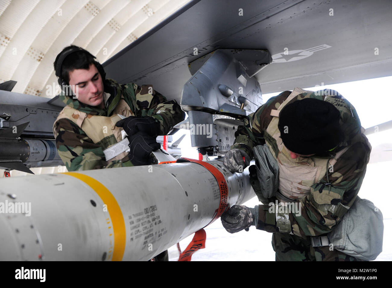 Senior Airman Mark Smith und Staff Sgt. Jared Carroll, 20 Expeditionary Aircraft Maintenance Squadron Waffen laden Besatzungsmitglied, sichert eine Luft-Boden-Rakete (AGM-88) Auf eine F-16 Fighting Falcon bei einer Halbinsel Betriebsbereitschaft Übung in Kunsan Air Base, Republik Korea Jan 31, 2012. PENOREs sicherzustellen, dass der Wolf Pack Mitglieder in der Lage sind, ihre Aufgaben in Kriegszeiten. Beide Flieger ist von Shaw Air Force Base, S.C. (USA bereitgestellt Air Force Foto: Staff Sgt. Rasheen A. Douglas/Freigegeben) Besatzungsmitglieder, sichert ein Luft-zu-Rakete auf eine F-16 Fighting Falco Stockfoto