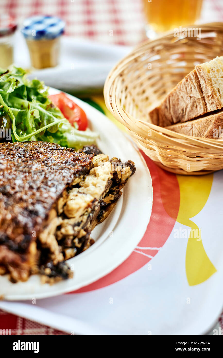 Ein rustikales Wild Mushroom frittata mit frischem Brot auf einer französischen Cafe table top in der Dordogne Frankreich Stockfoto