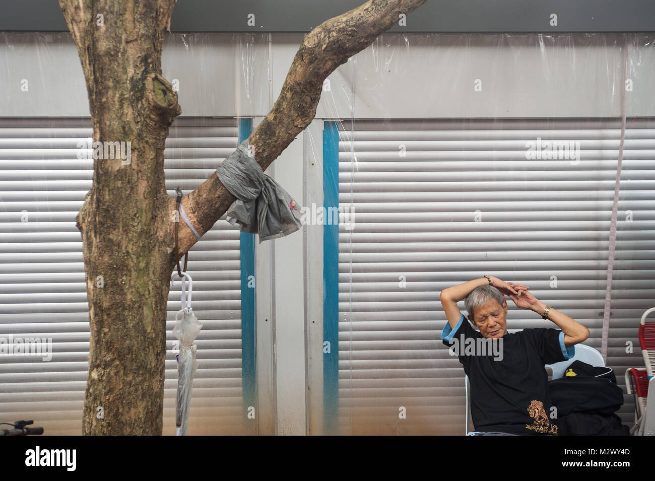 27.01.2018, Singapur, Republik Singapur, Asien - ein Mann sitzt an einem öffentlichen Platz neben dem Buddha Zahns Tempel in Singapur Chinatown. Stockfoto