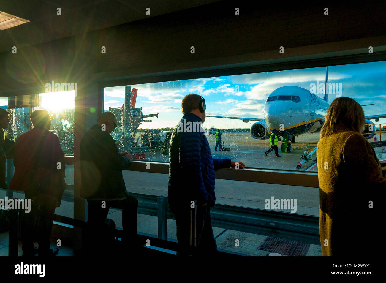 Passagiere warten, um einen Ryanair Flug am Flughafen Bristol board, Sunrise, wodurch Lichtreflexionen auf der linken Seite Stockfoto