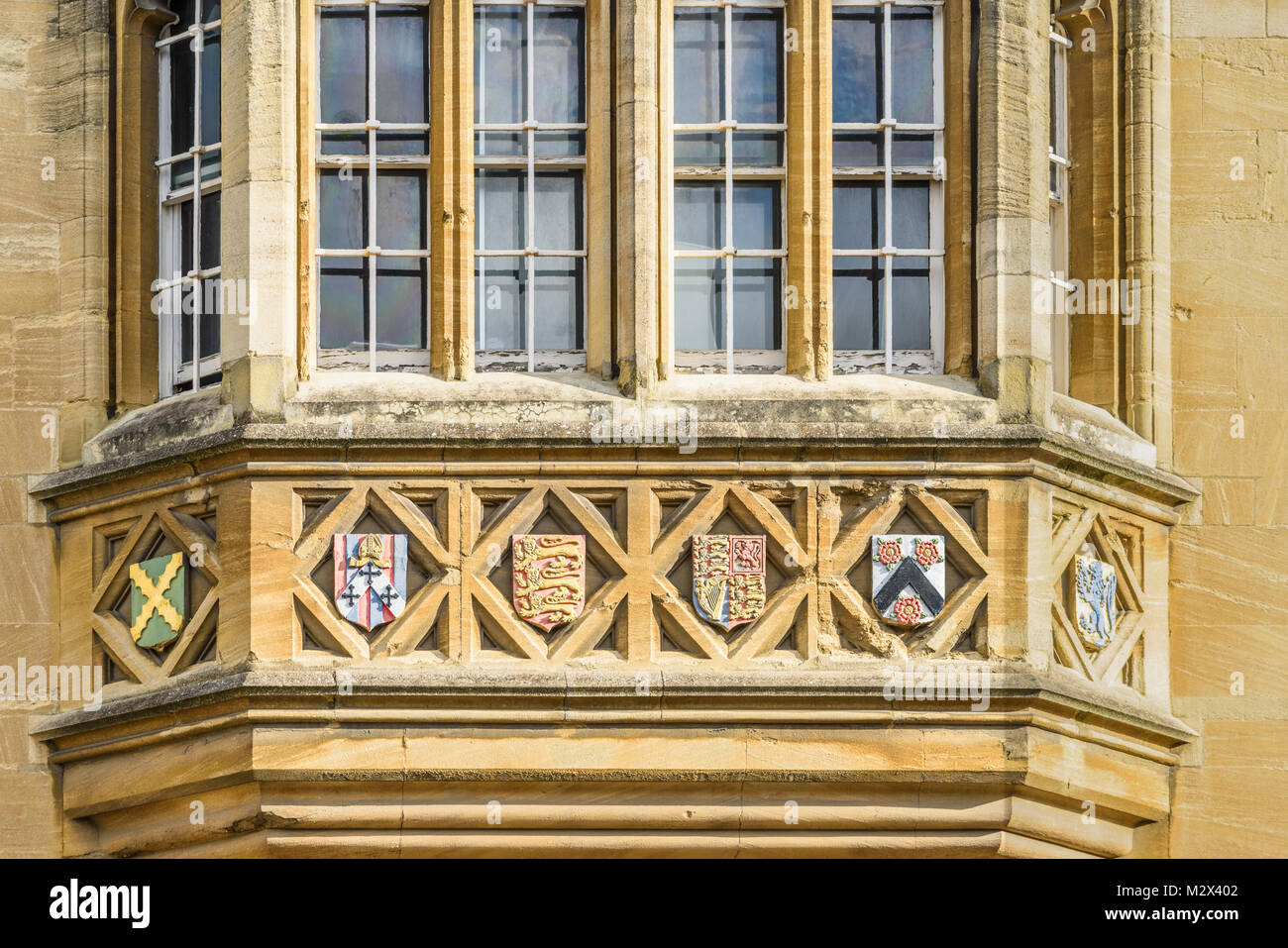 Stein-Embleme an einem Fenster zur Straßenseite des Oriel College an der Universität Oxford, England. Stockfoto