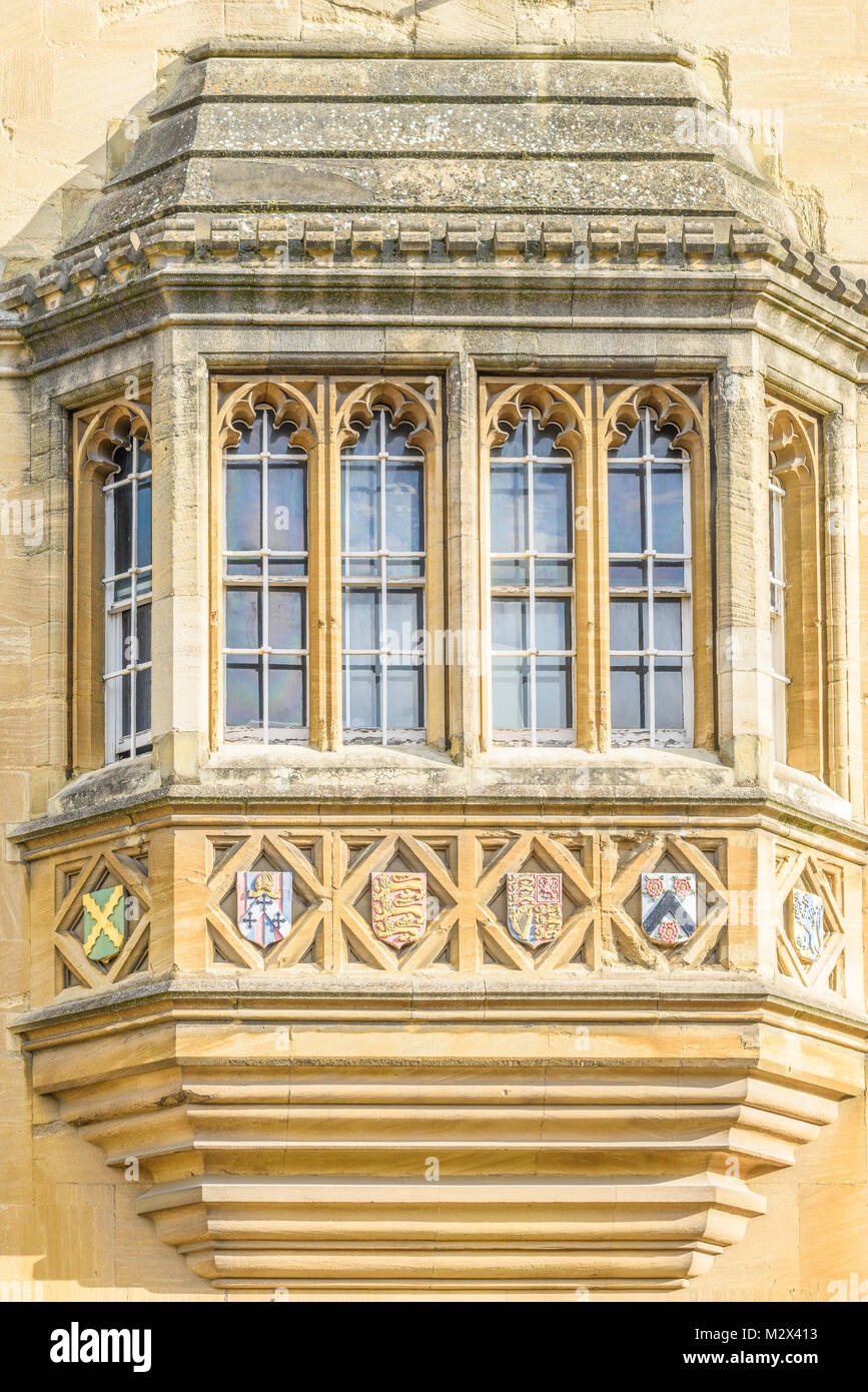 Reich verzierte Fenster zur Straßenseite mit Emblemen der Oriel College an der Universität Oxford, England. Stockfoto