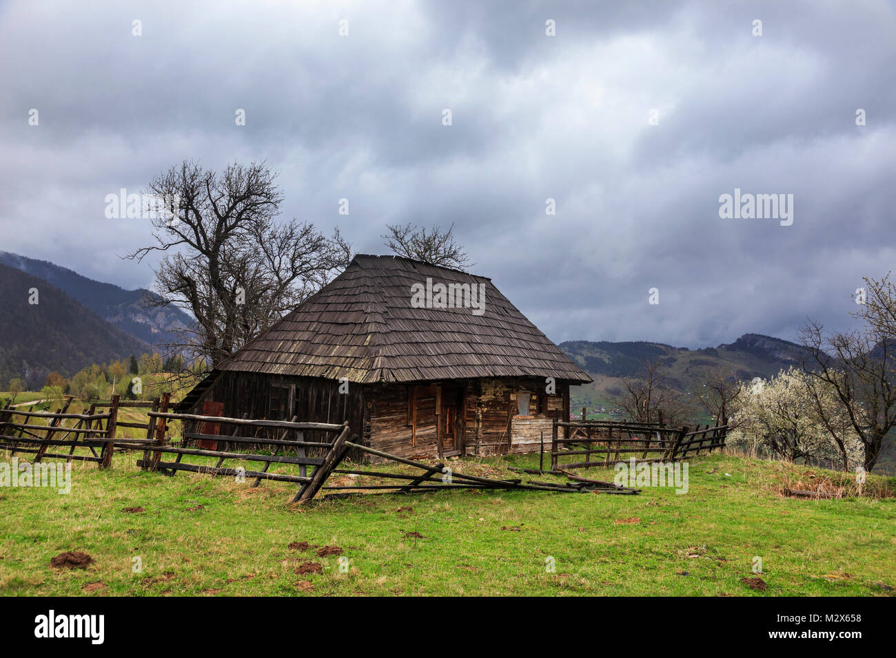 Kleine alte Holz- Bauernhaus, in einem Feld aufgegeben, auf einer schönen bewölkt Frühling in Rumänien Stockfoto