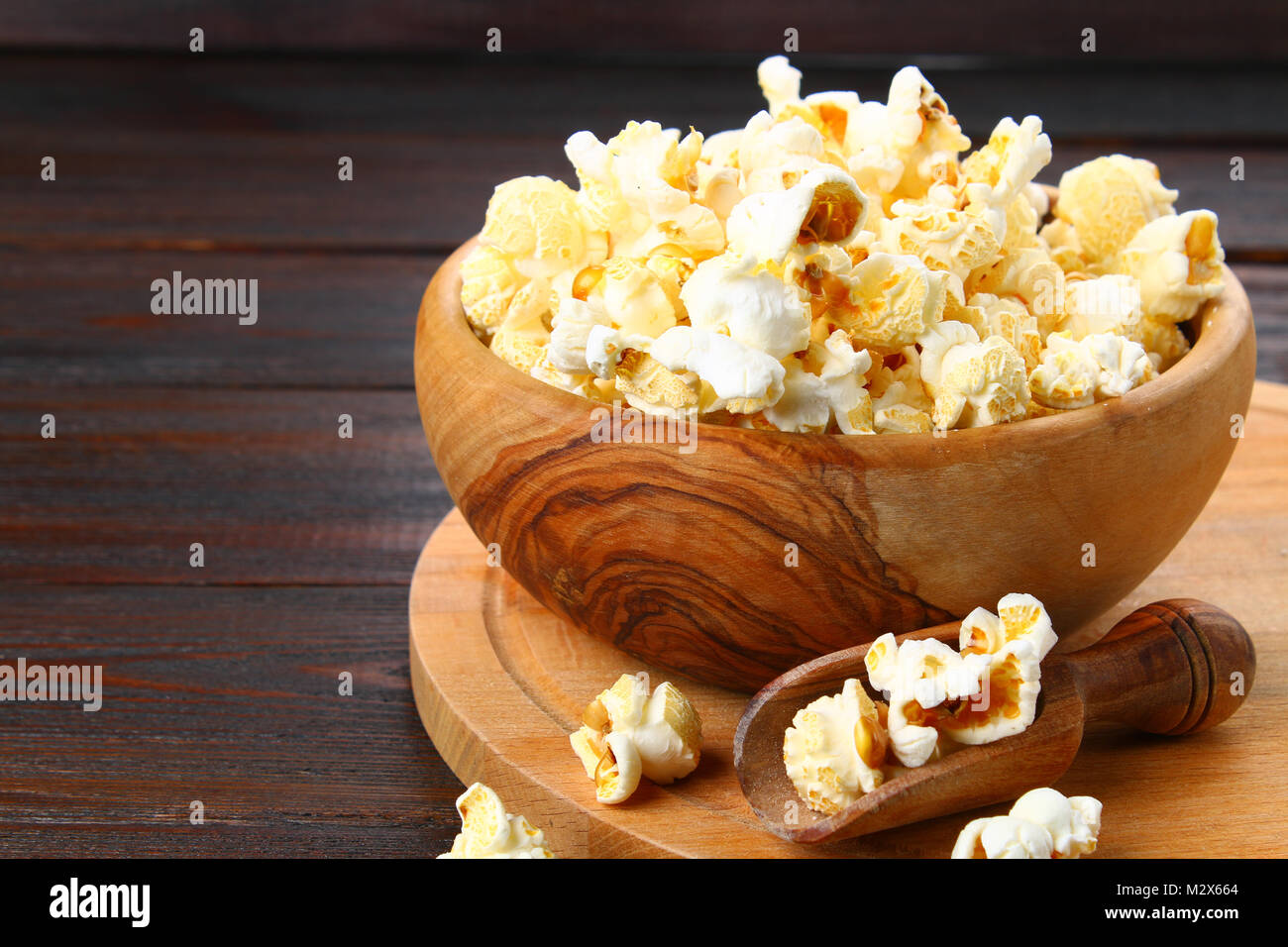 Gesalzene Popcorn in eine hölzerne Schüssel auf einen hölzernen Tisch Stockfoto