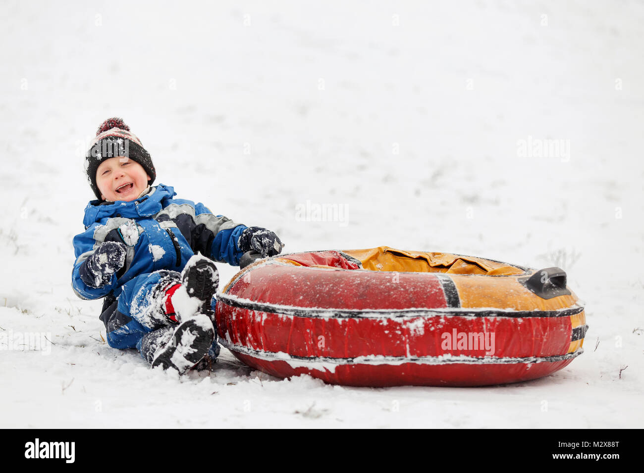 Foto von Happy Boy mit Schläuchen in Winter Park Stockfoto