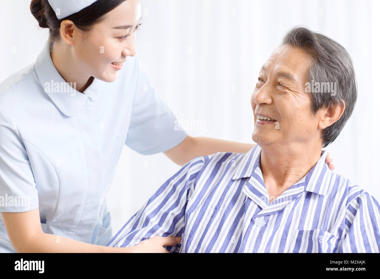 Krankenschwestern Pflege eines kranken älteren Menschen Stockfoto