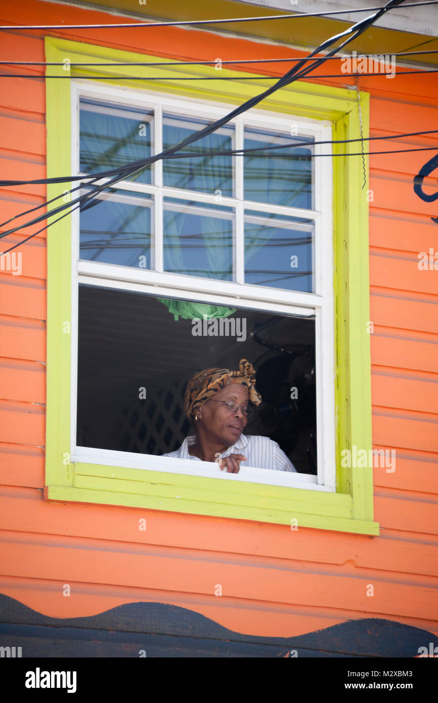 Nahaufnahme eines afro-karibische Frauen saßen, aus einem alten Holzhaus Fenster Rahmen auf der karibischen Insel St. Vincent Stockfoto