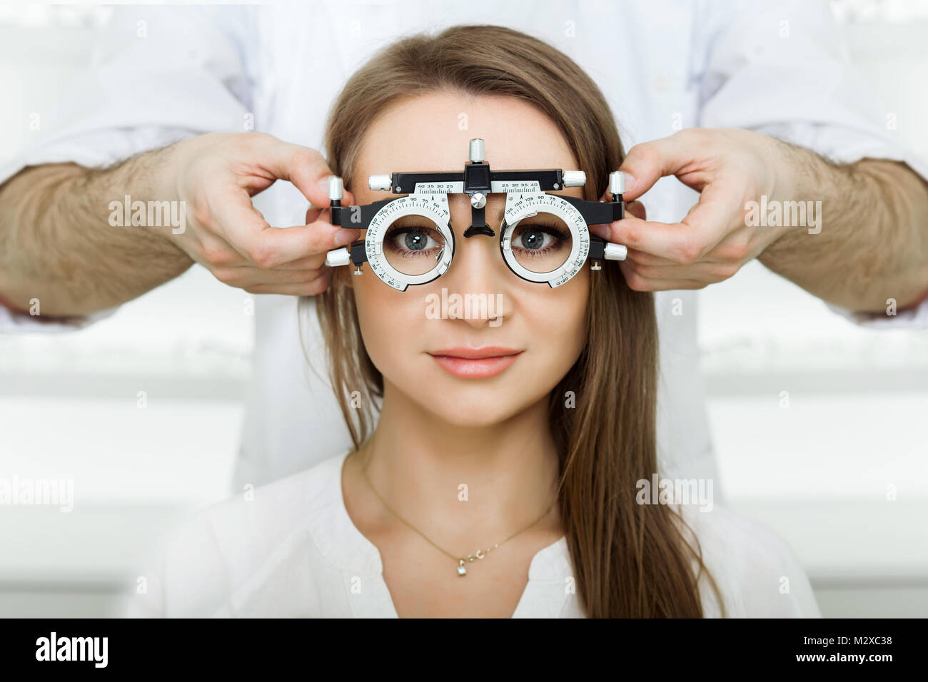 Der Augenarzt untersucht attraktive Frau mit Optometrist trial Rahmen. Patientin Vision in der ophthalmologischen Klinik zu prüfen. Stockfoto