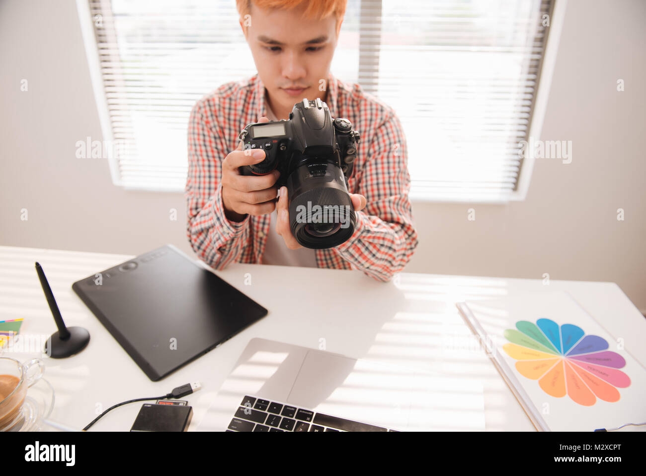 Stattliche männliche Graphic Designer bei Bilder in digitale Kamera im Büro suchen Stockfoto