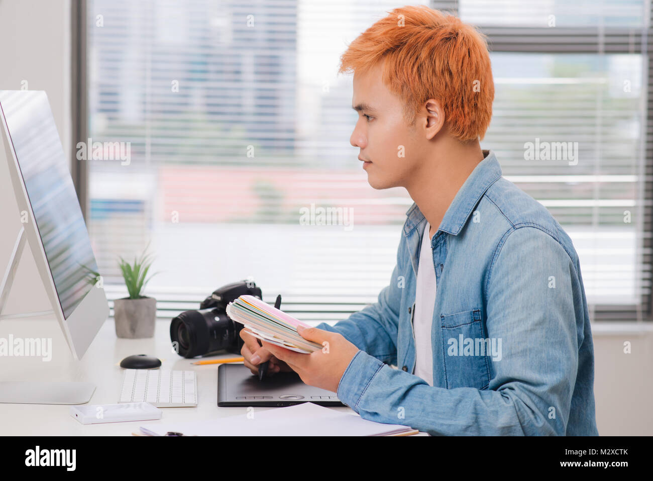 Fotograf am Schreibtisch arbeiten in modernen Büros Stockfoto