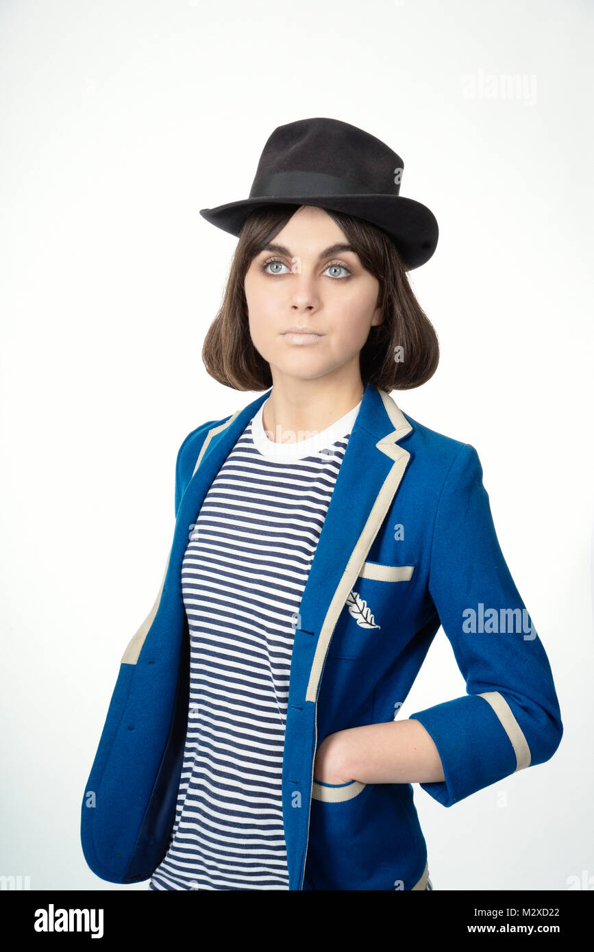 Schöne junge Mädchen - große blaue Augen sehr stilvolle Kleidung, Haar und Make-up. Stellt in einer sehr Mannequin wie Weise, leeren Ausdruck, isoliert Stockfoto