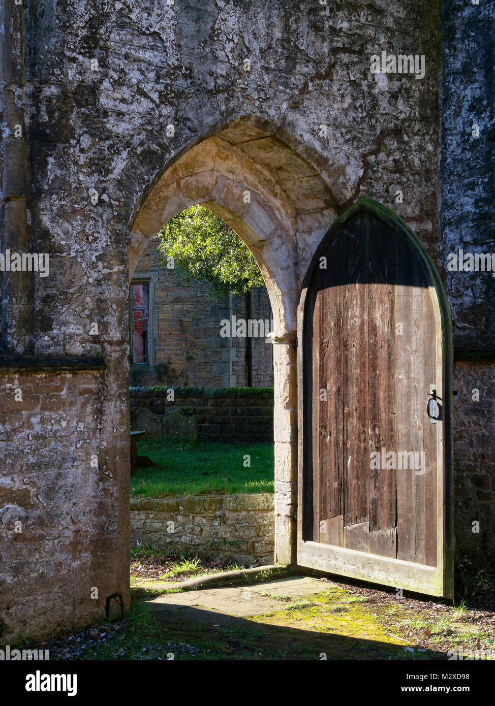 In den Ruinen einer mittelalterlichen Kirche der offenen Tür können im Winter Sonnenlicht Stockfoto