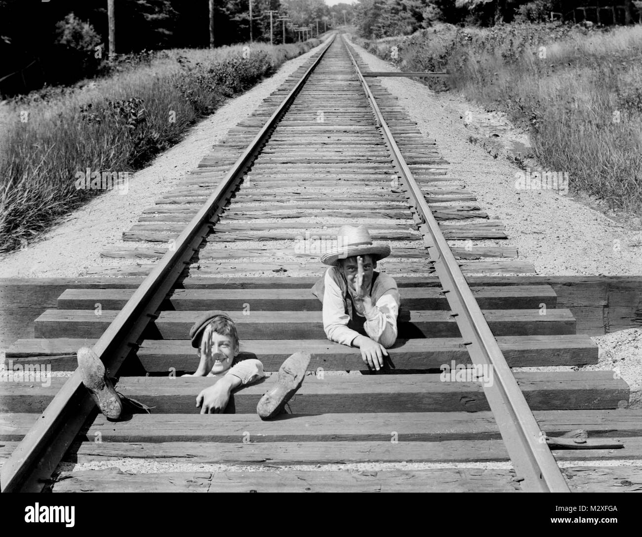 Zwei delinquenten Teenager die Geste und Spielen auf den Eisenbahnschienen, Ca. 1910. Stockfoto