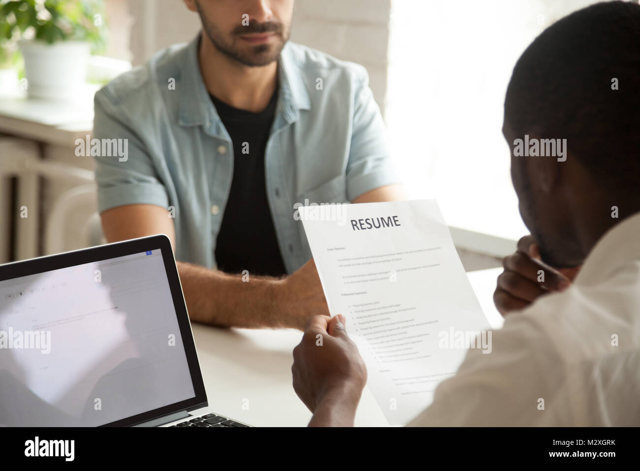 African American hr manager Holding Bewerber Lebenslauf, Vorstellungsgespräch, schwarz Personalvermittler oder Arbeitgeber in Betracht cv der kaukasischen Vakanz cand. Stockfoto